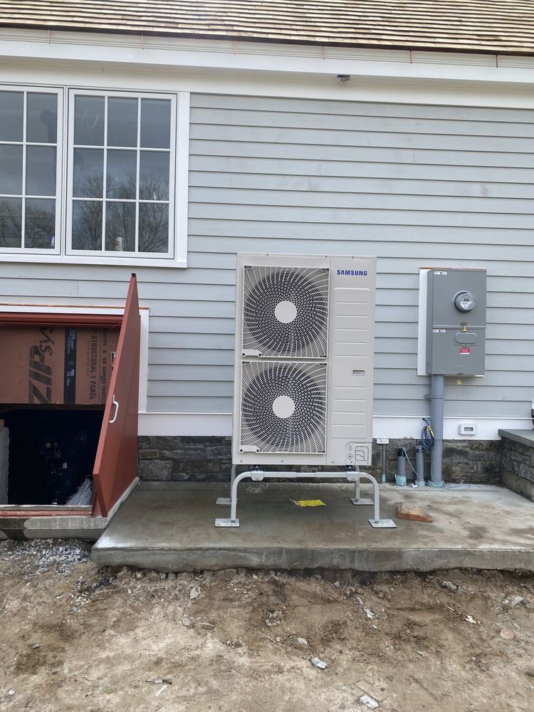 A large air conditioner is sitting on the side of a house.