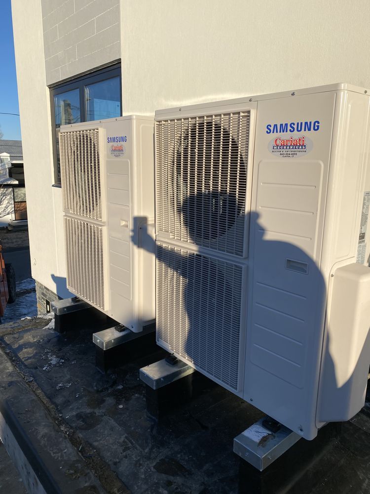 A samsung air conditioner is sitting on the side of a building.
