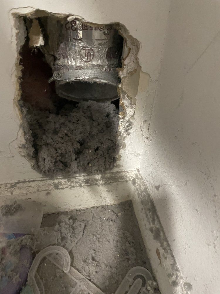 A hole in the wall with a pipe coming out of it.