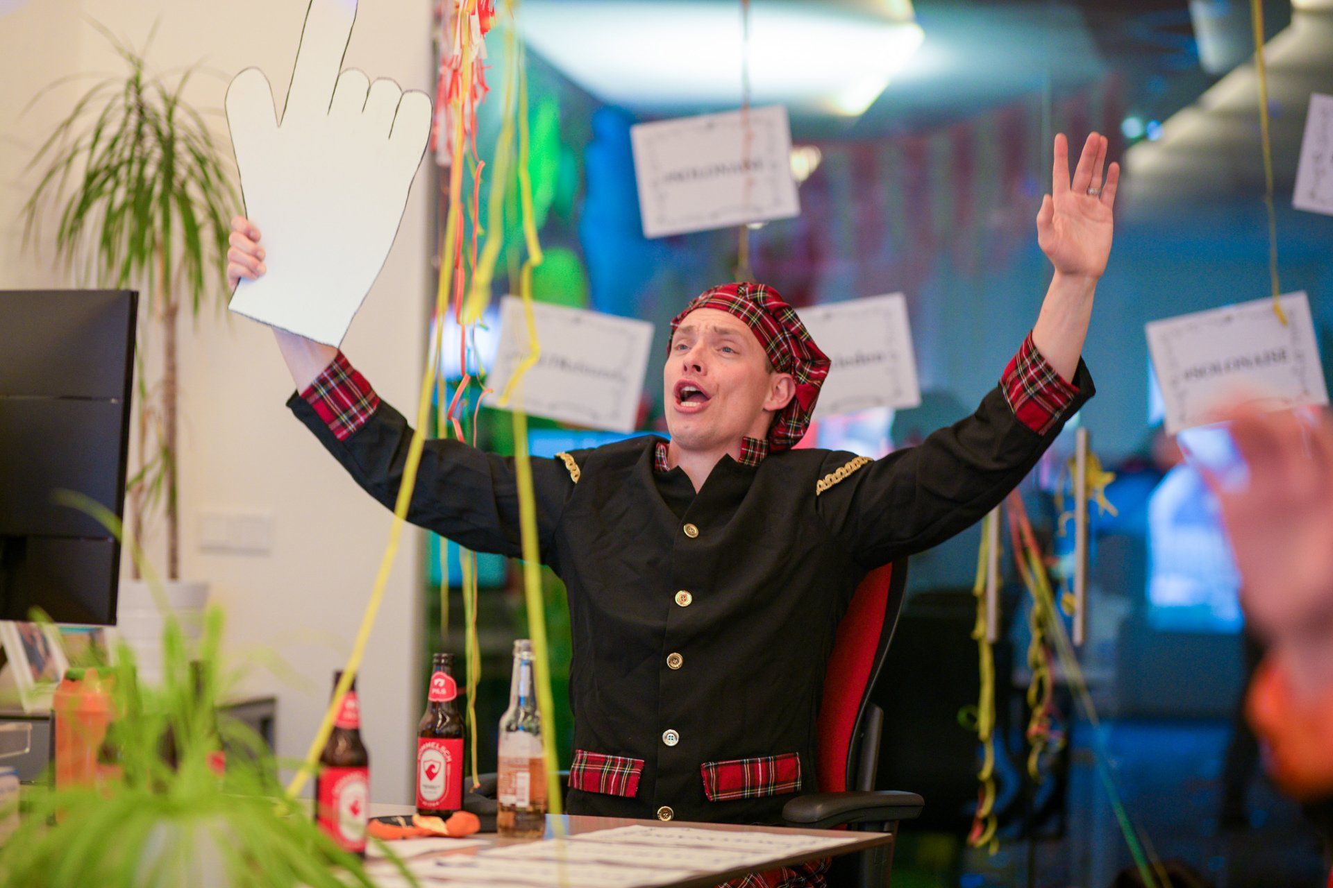 Een man zit aan een bureau met zijn armen uitgestrekt en een vel papier in zijn hand.