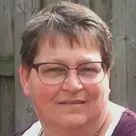 Een vrouw in een stippenshirt lacht in een cirkel.
