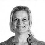 Een vrouw lacht op een zwart-witfoto.