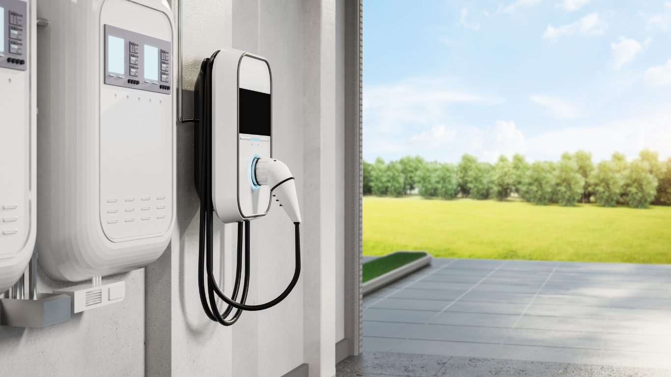 EV charger plugged in, mounted on a wall, with a sunny outdoor view.