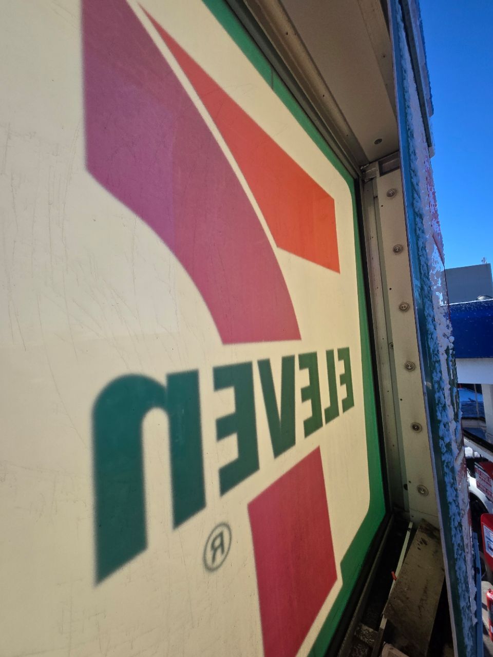 Man in red shirt installing a ceiling fan in a room with a white ceiling.