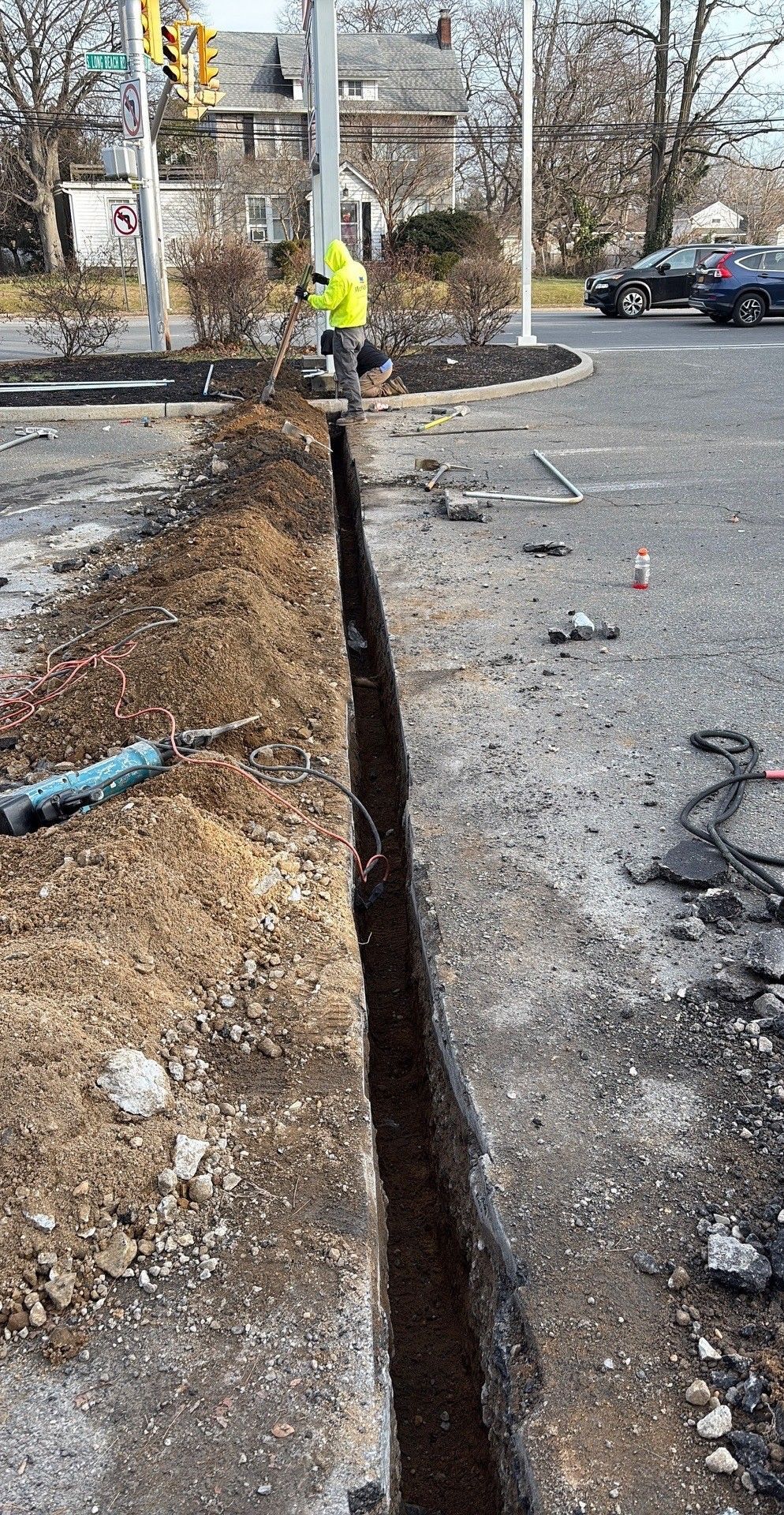 Man in a brown hoodie and cap installing a ceiling fan in a room.