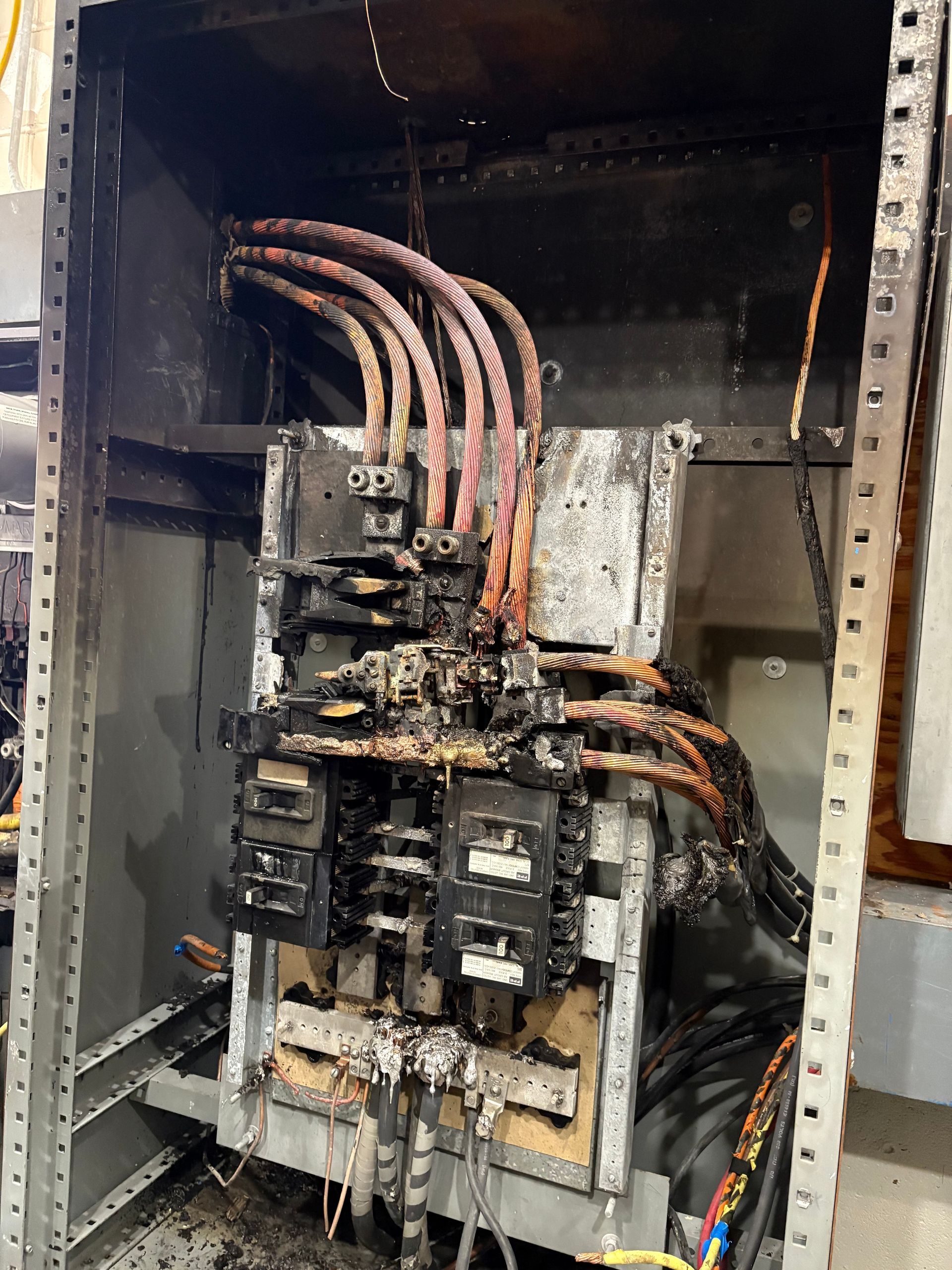 Man in red shirt installing a ceiling fan in a room with a white ceiling.
