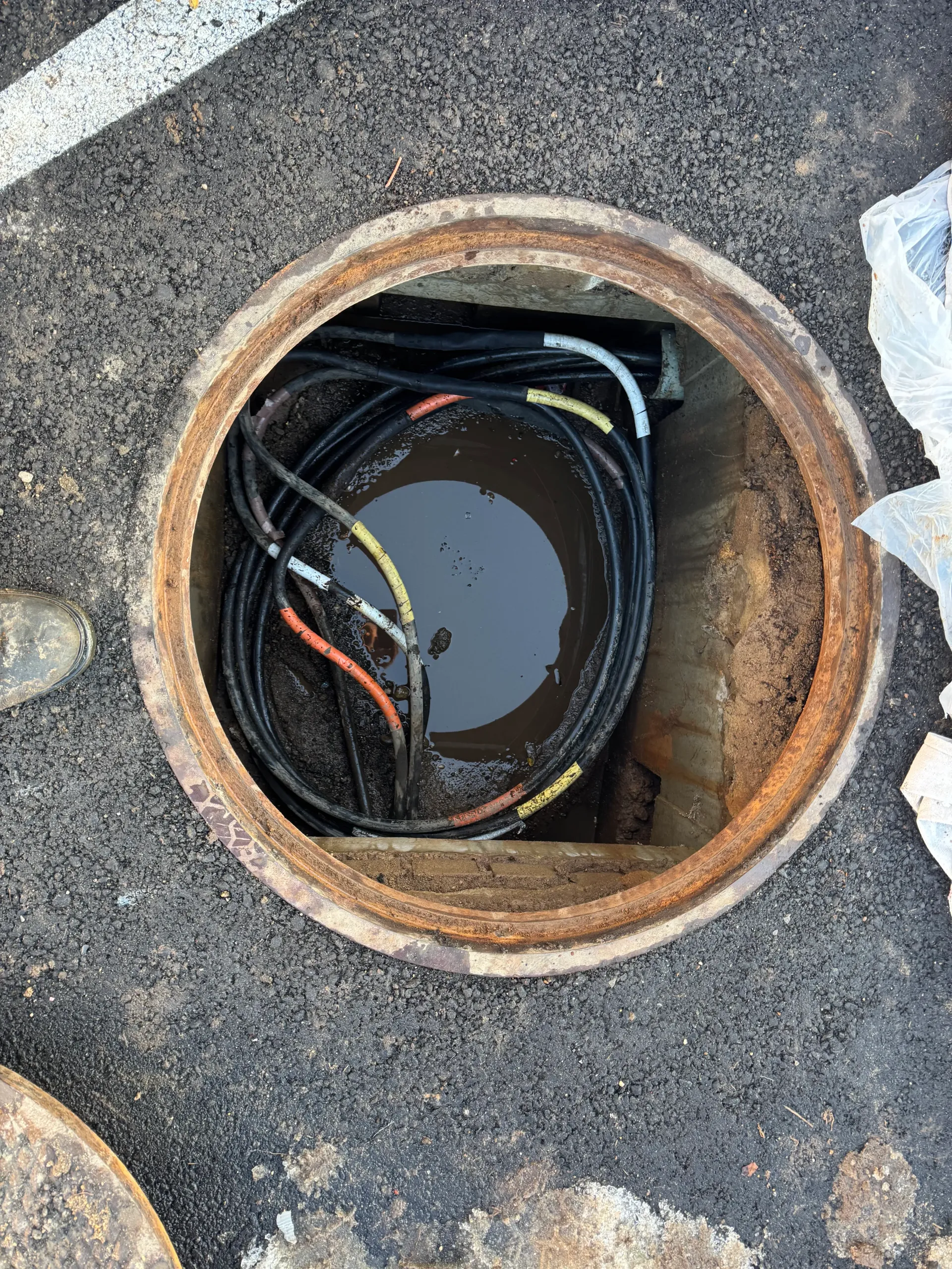 Man in red shirt installing a ceiling fan in a room with a white ceiling.