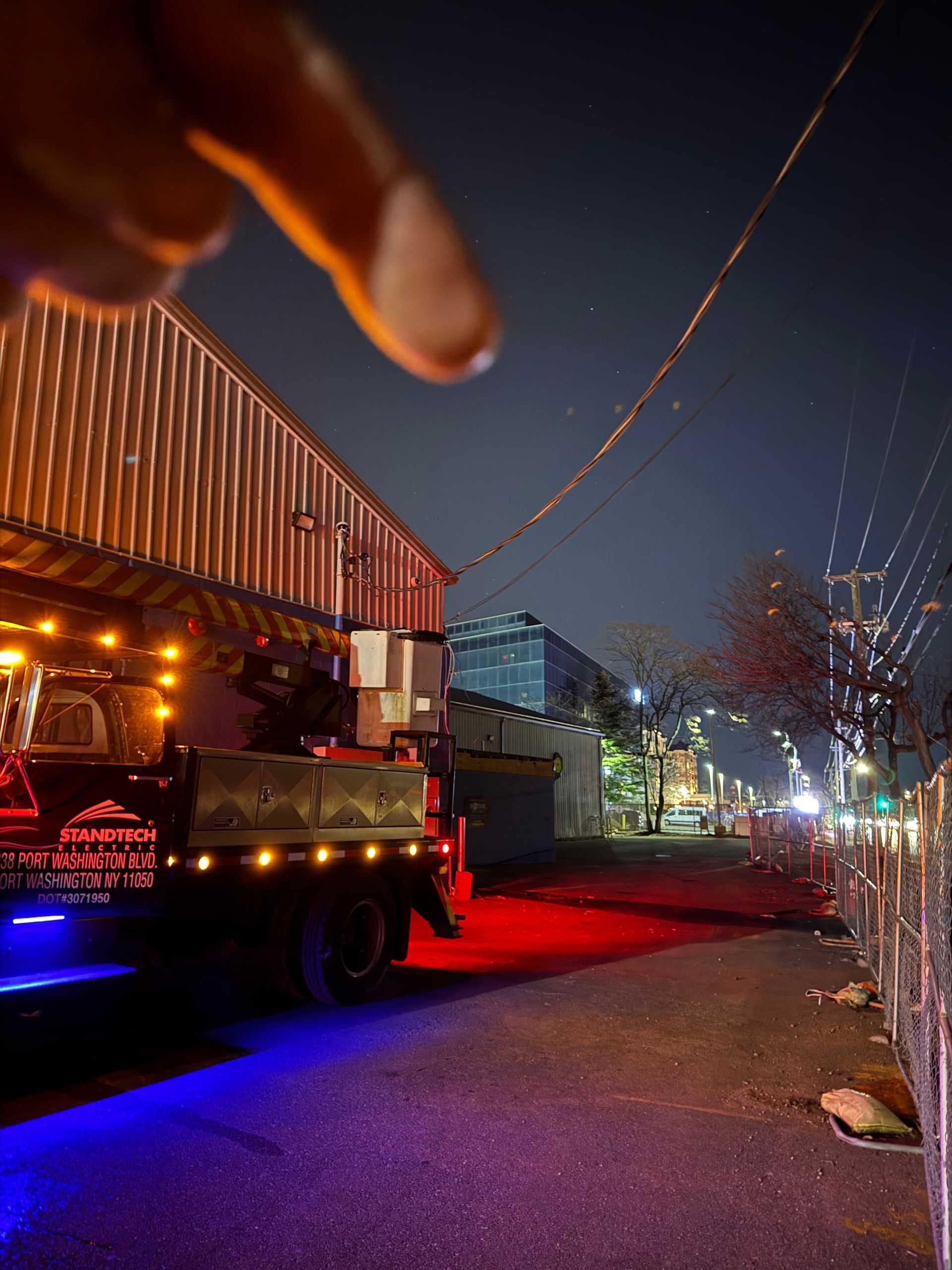 Man in red shirt installing a ceiling fan in a room with a white ceiling.