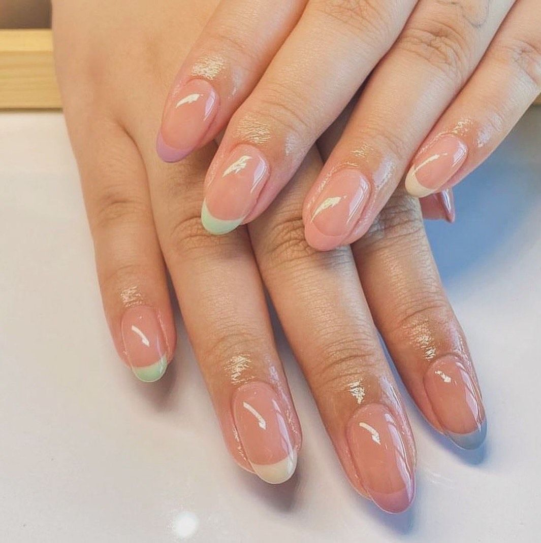 A close up of a woman 's nails with a french manicure