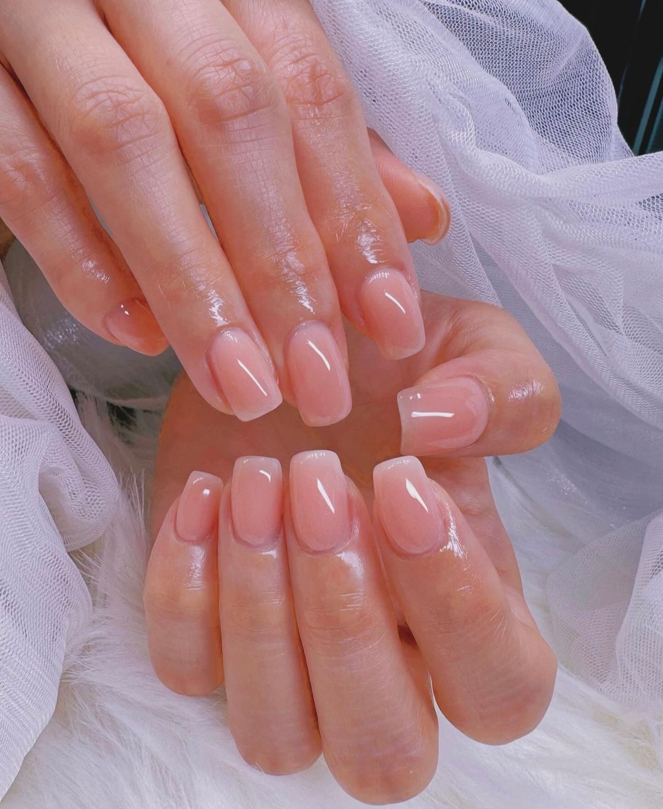 A close up of a woman 's nails on a white surface.