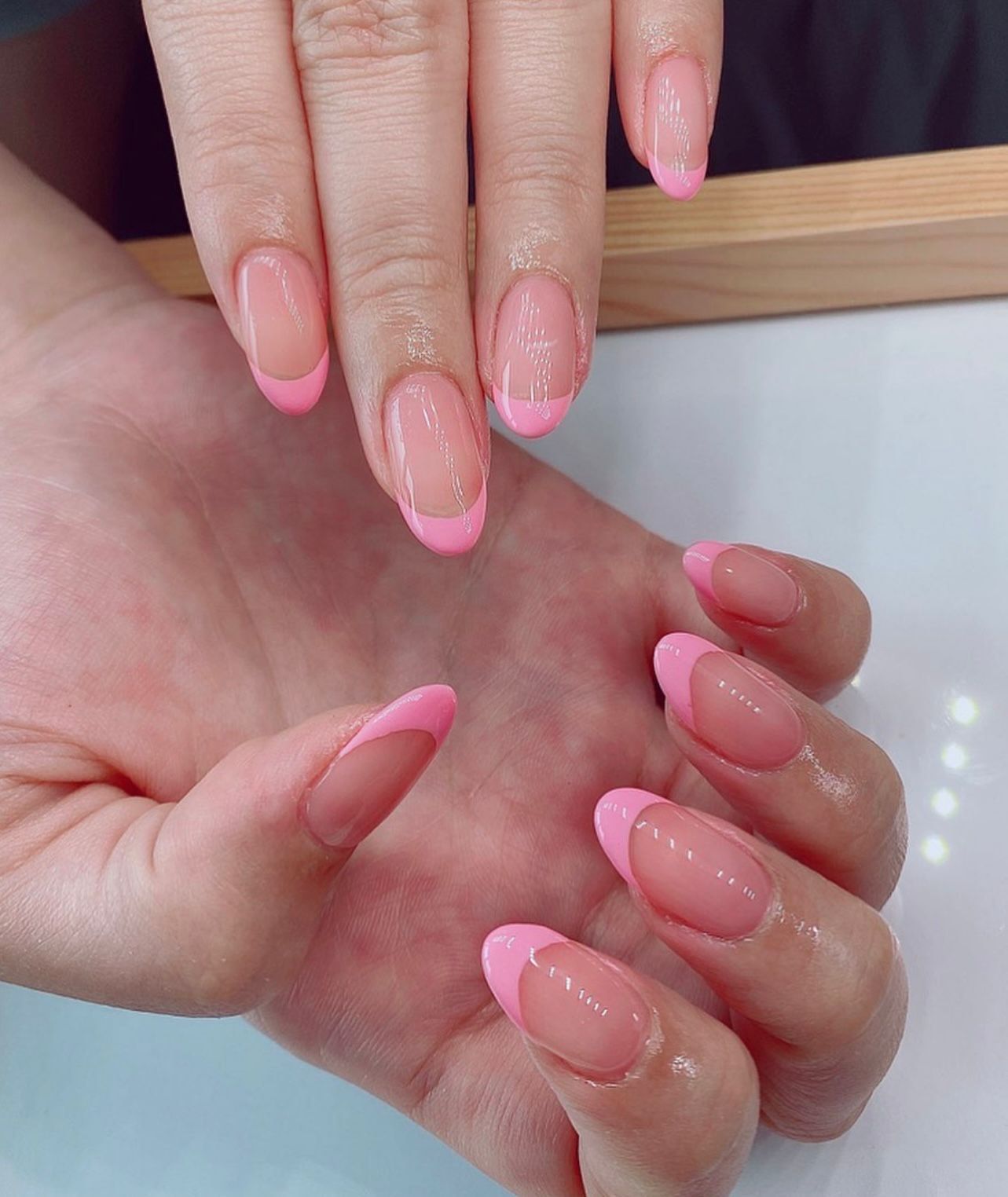 A close up of a woman 's hand with pink nails