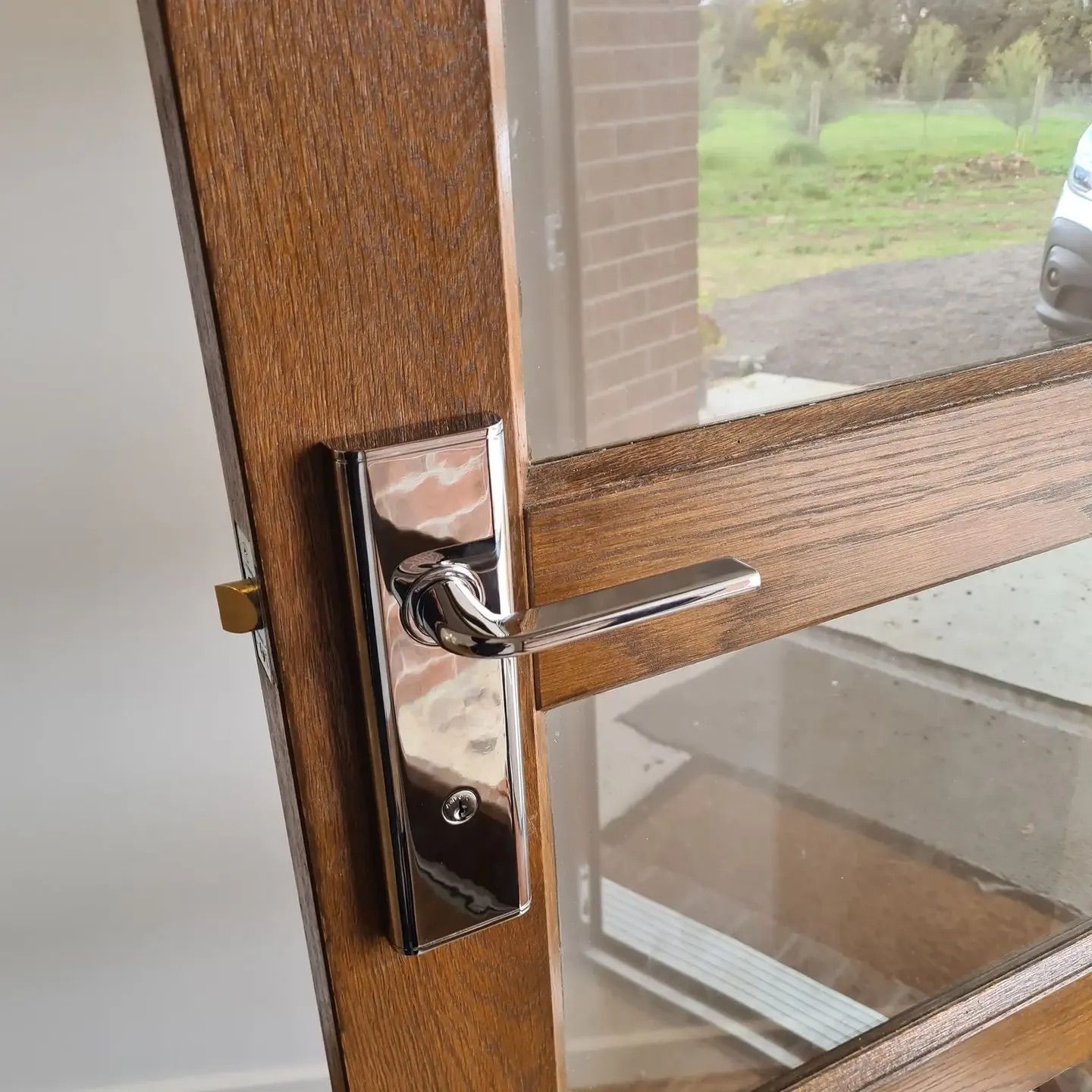 A Yellow Door With A Silver Handle Is Open To A Room With A Couch — Barwon Locksmith & Security Doors in Grovedale, VIC