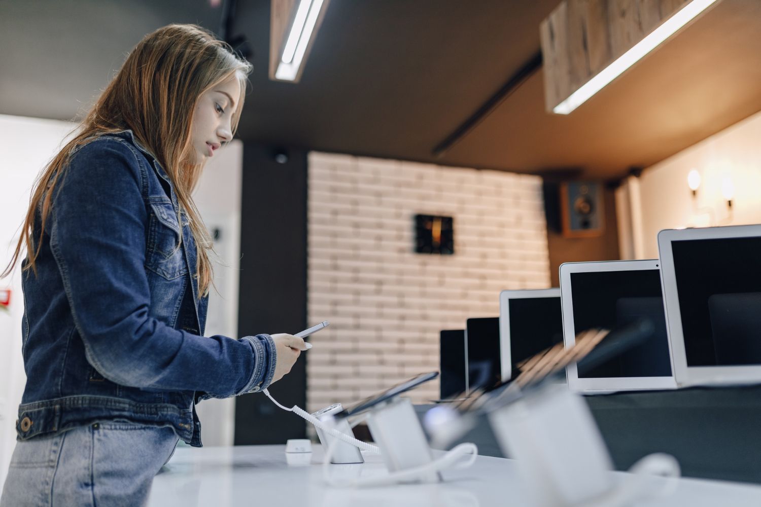 A woman is looking at a tablet in a store.