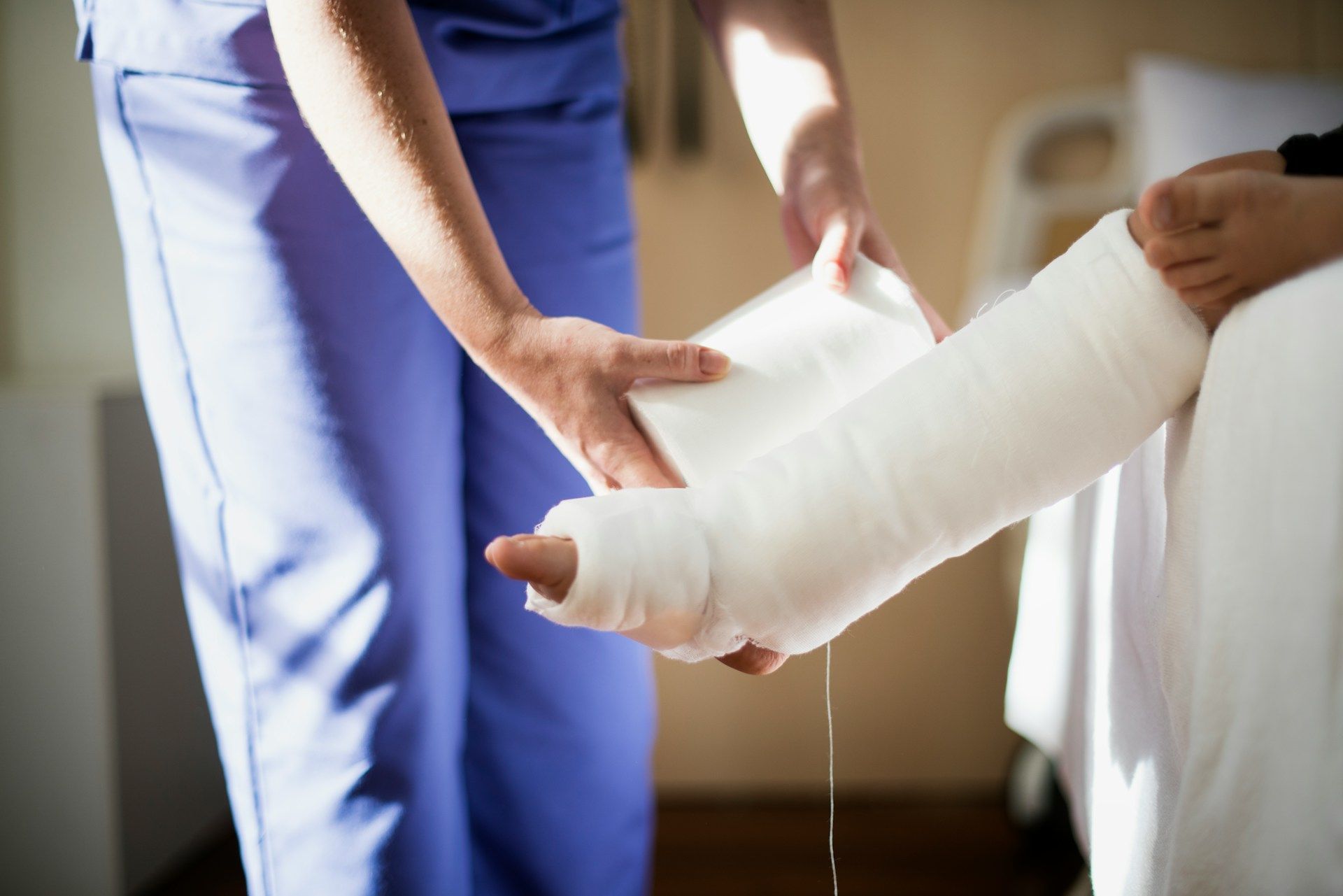 A nurse is putting a cast on a patient 's leg.