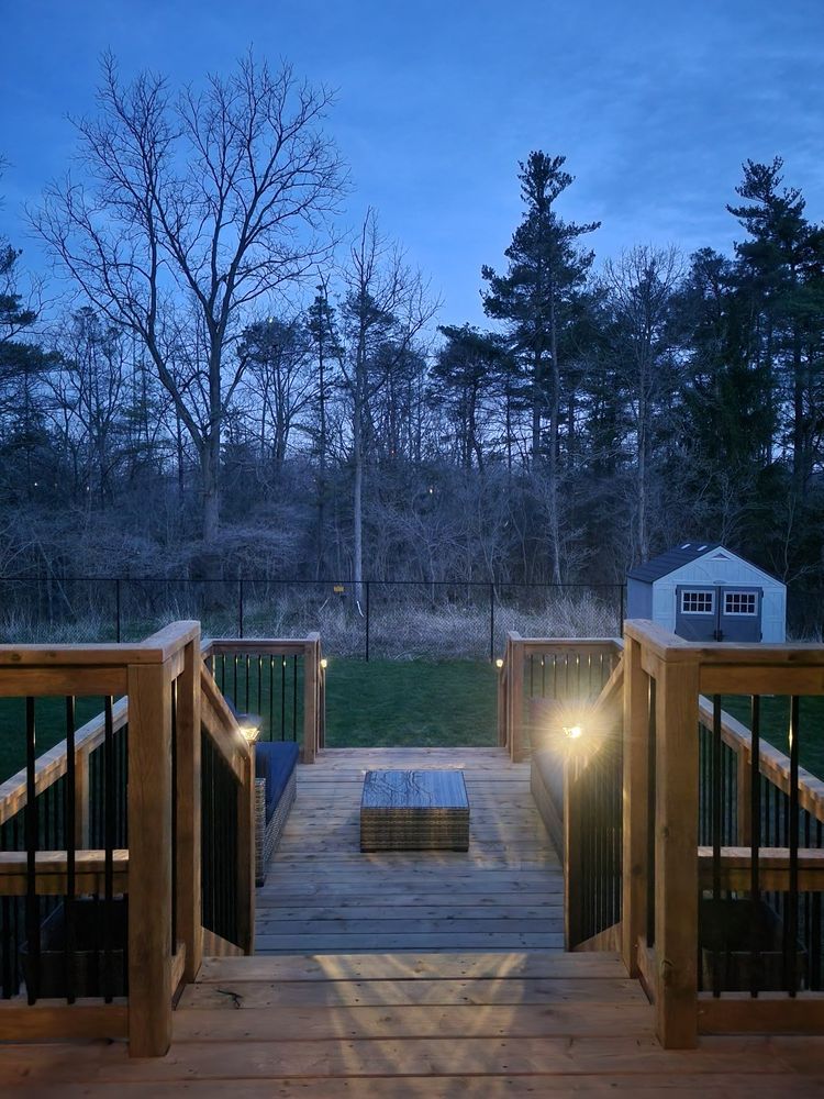 A wooden deck with stairs leading up to it at night