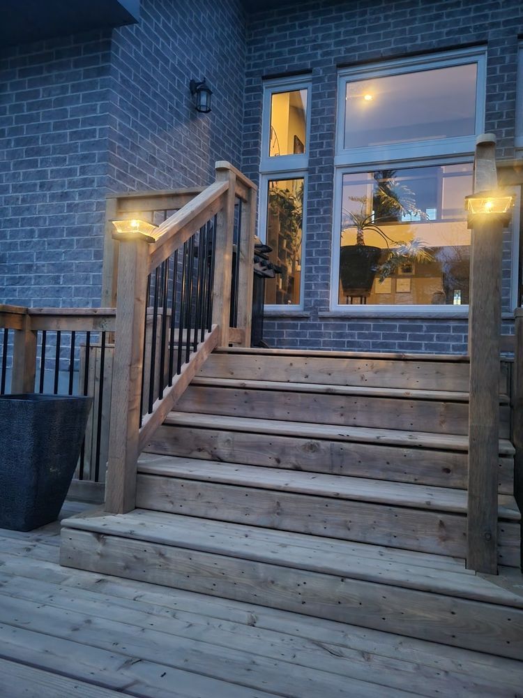A wooden deck with stairs leading up to a brick house