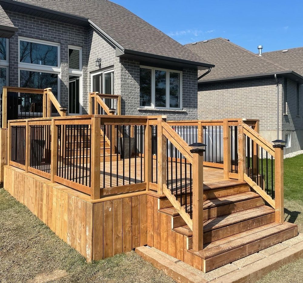 A wooden deck with stairs is in front of a house.