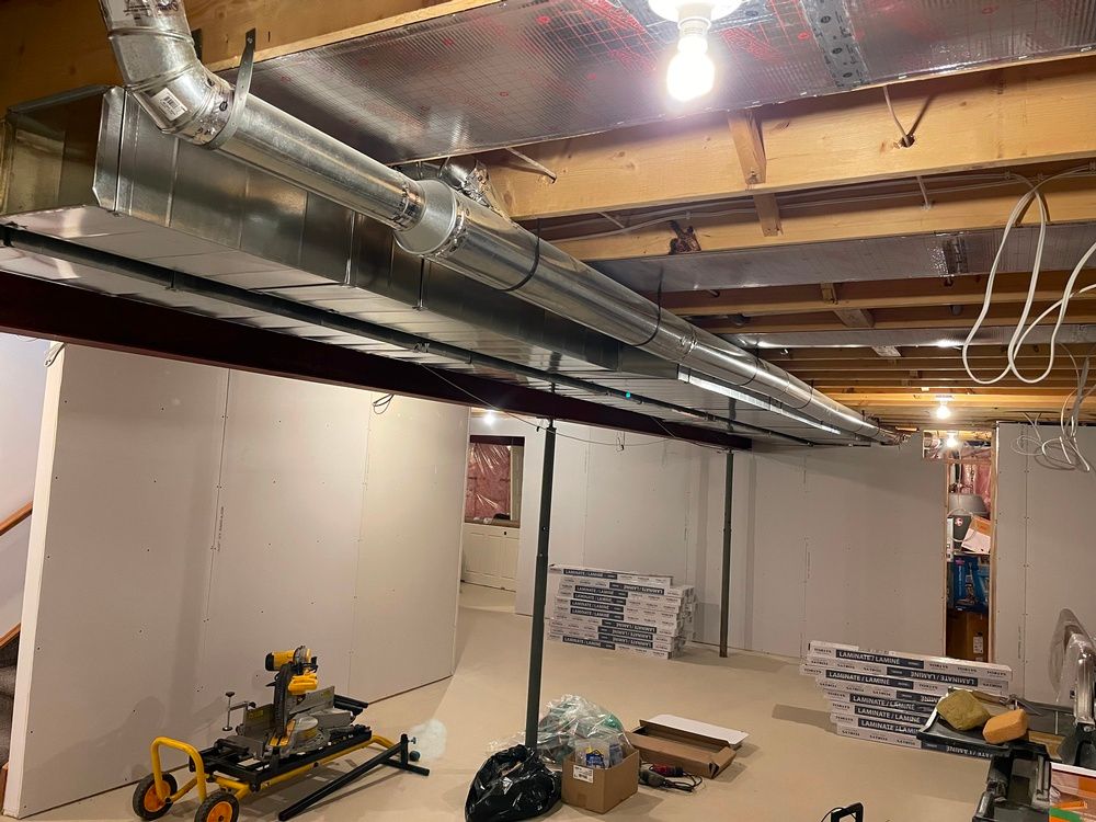 A basement with a lot of pipes hanging from the ceiling.