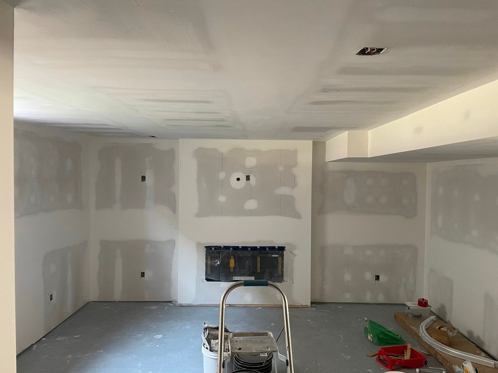 A room with drywall on the walls and a fireplace.