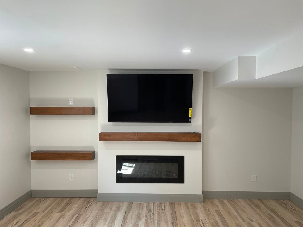 A living room with a fireplace and a flat screen tv on the wall.
