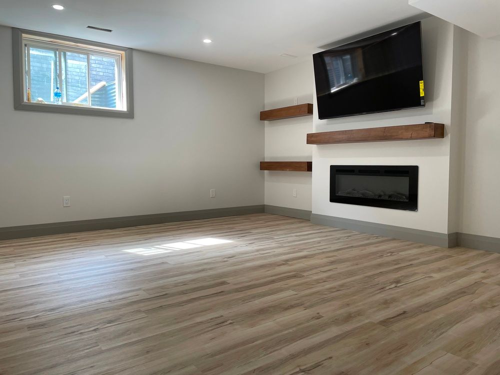 A living room with a fireplace and a flat screen tv on the wall.