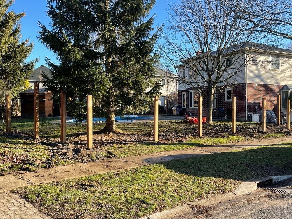A wooden fence is being built in front of a house.