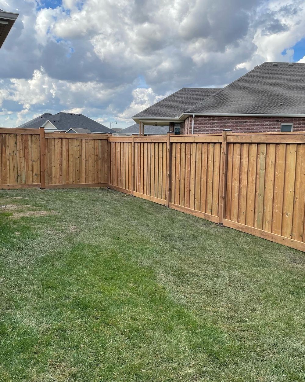 There is a wooden fence in the backyard of a house.