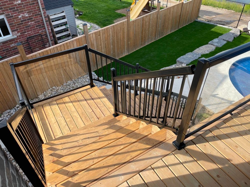 A wooden deck with stairs leading up to a pool.