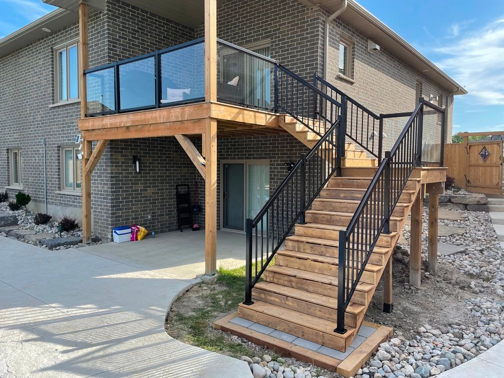 A house with a wooden deck and stairs leading up to it.
