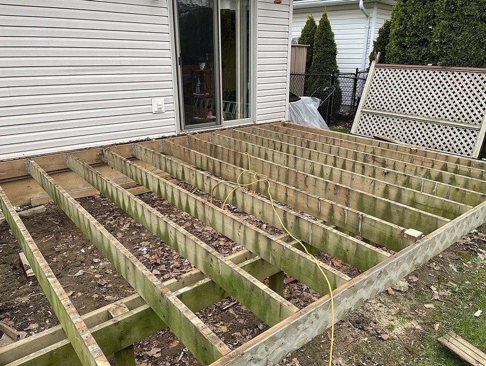 A wooden deck is being built in front of a house.