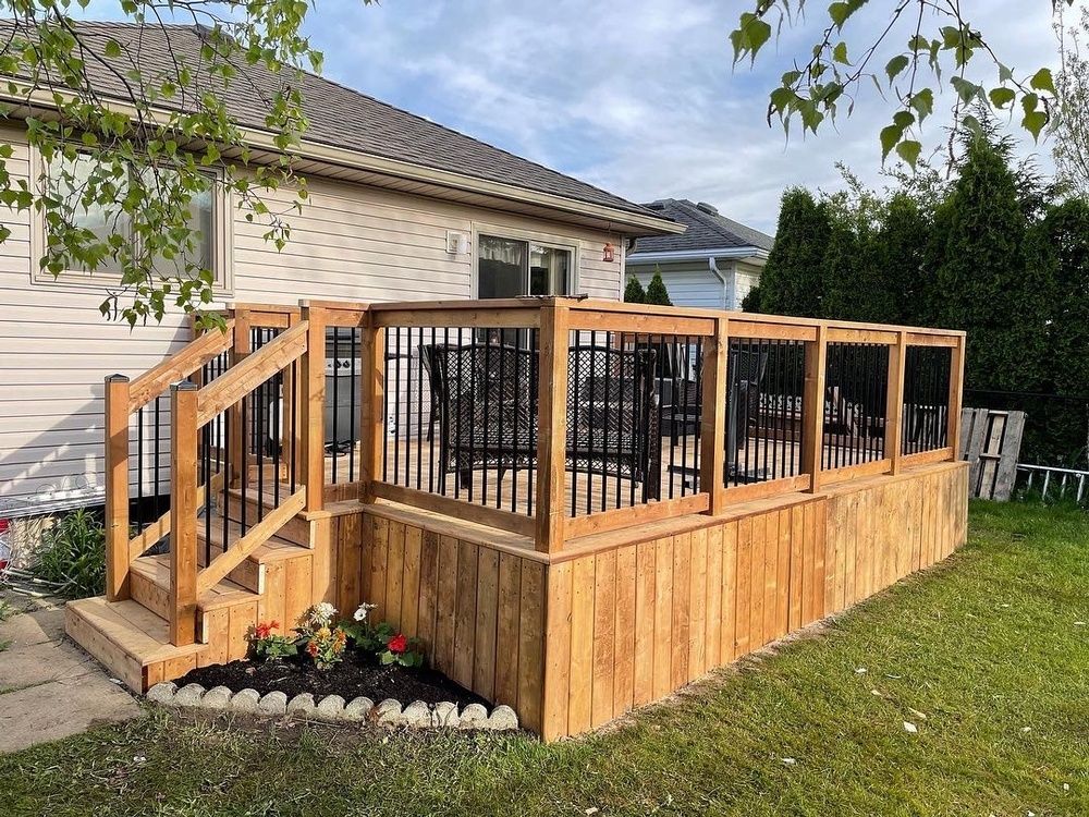 A wooden deck with stairs is in the backyard of a house.