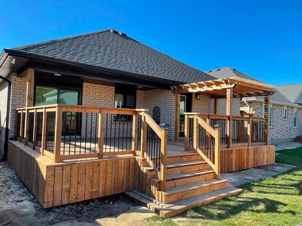 A house with a wooden deck and stairs in front of it.