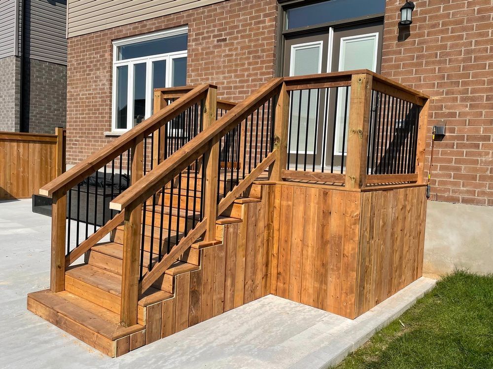 A wooden deck with stairs leading up to a brick house.