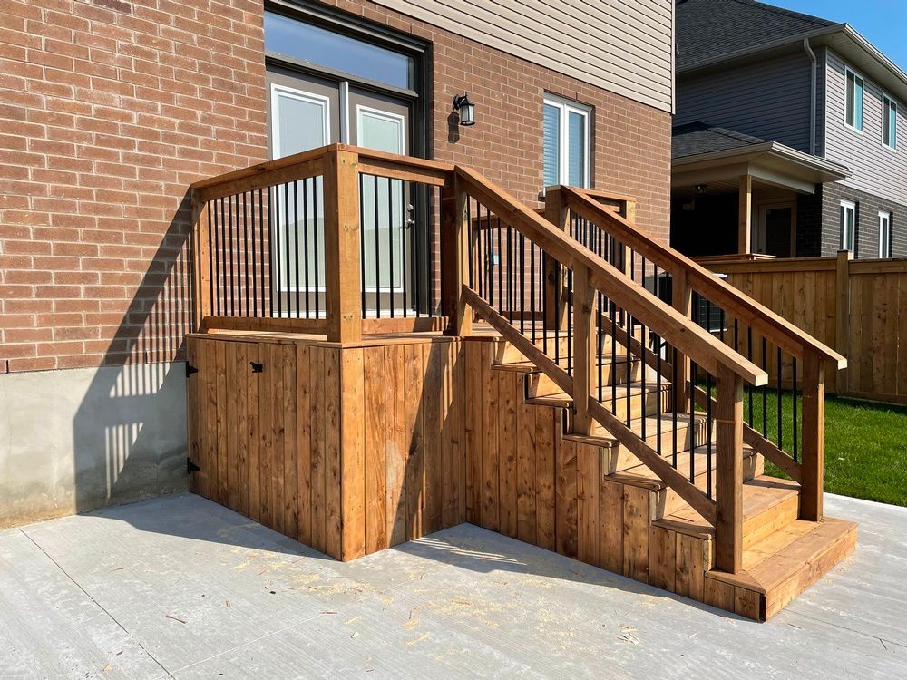 A wooden deck with stairs leading up to a brick house.