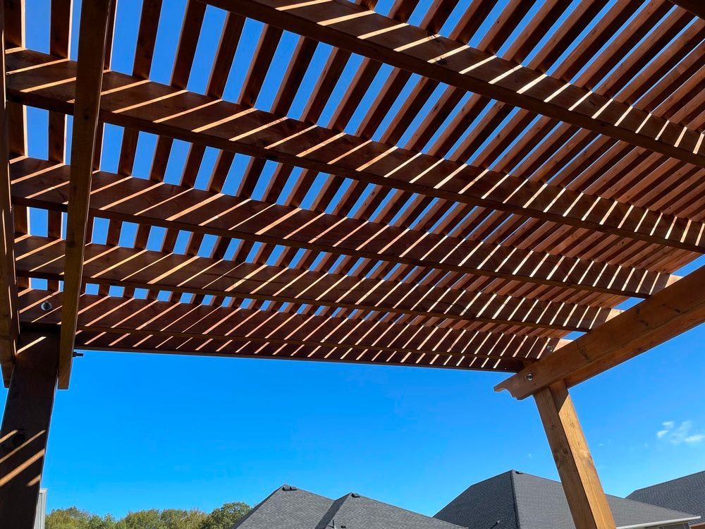 A wooden pergola with a blue sky in the background
