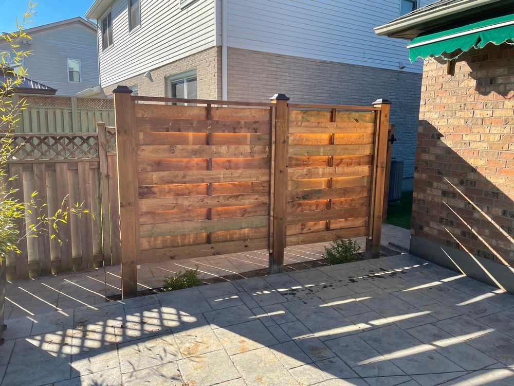 A wooden fence with a gate in the backyard of a house.