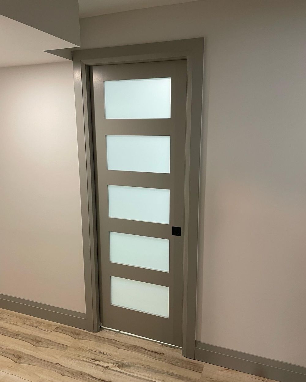 A door with a lot of windows in a hallway.