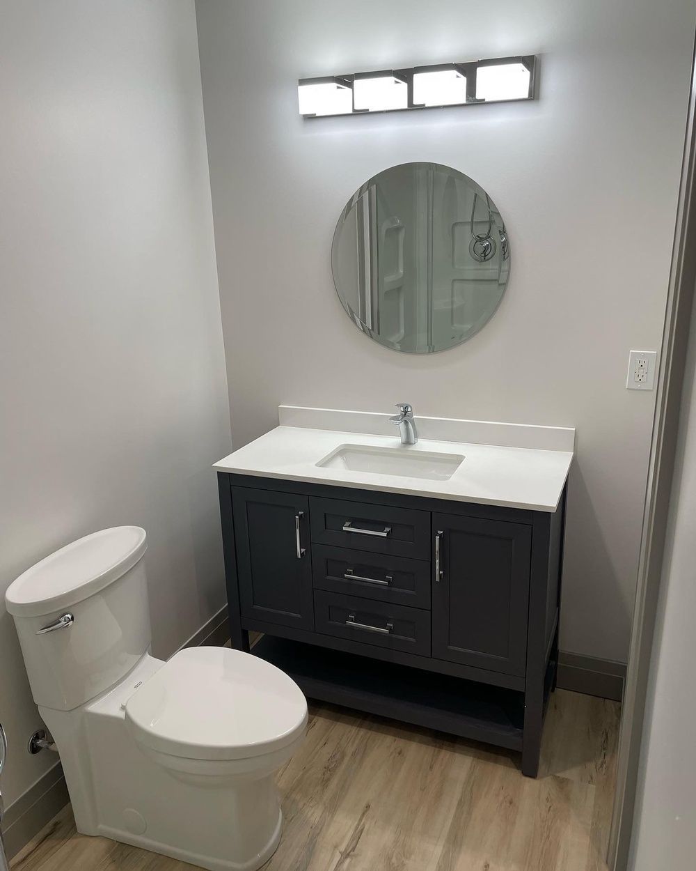 A bathroom with a toilet , sink and mirror.