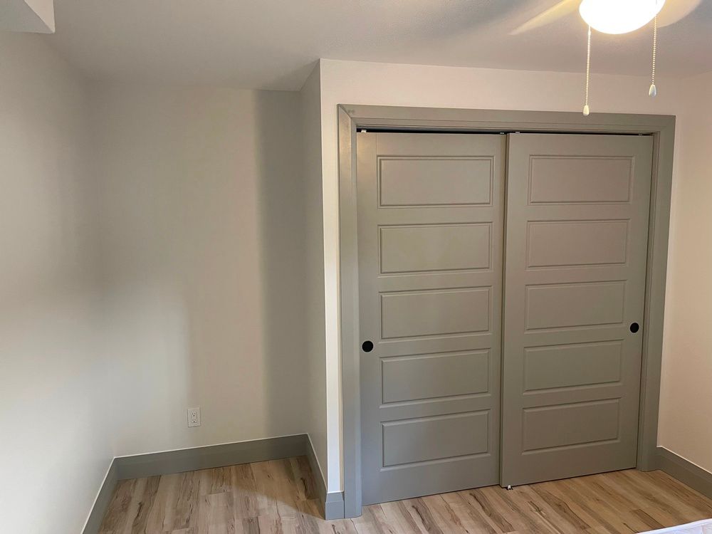 A bedroom with sliding doors and a light on the ceiling.