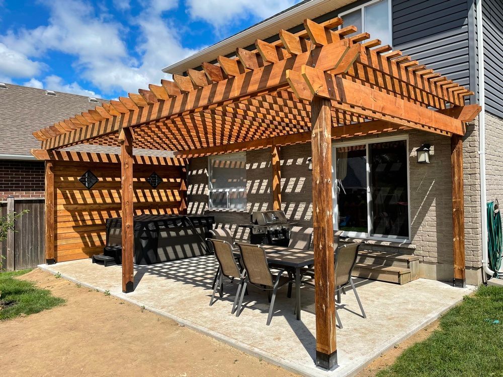 There is a pergola with a table and chairs underneath it.