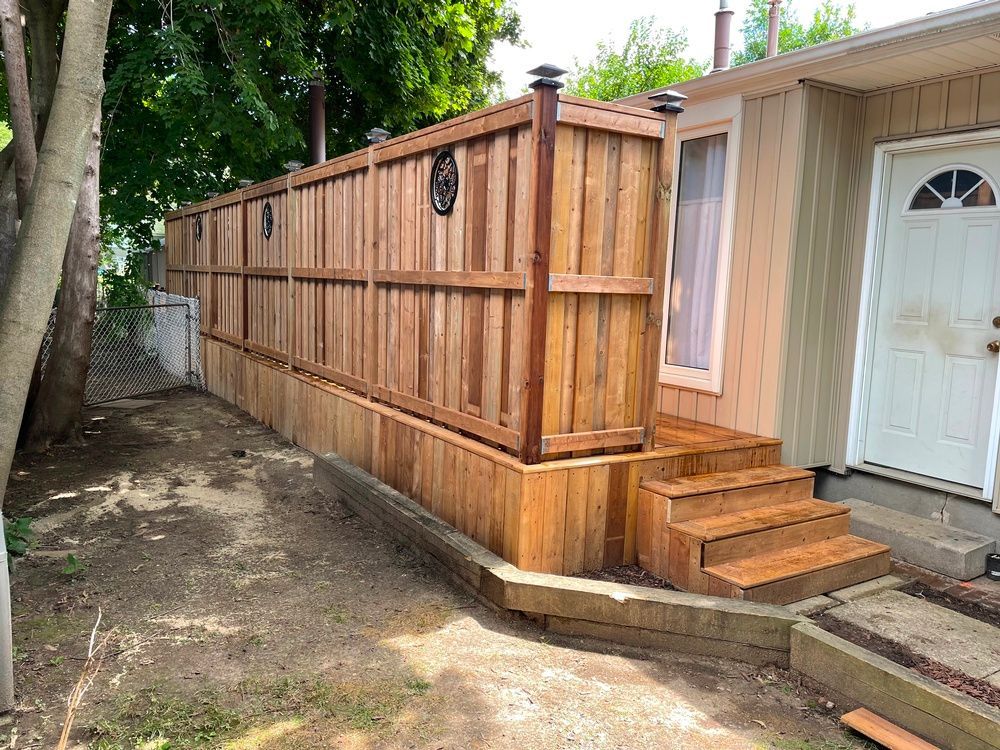 A wooden fence with stairs in front of a house.