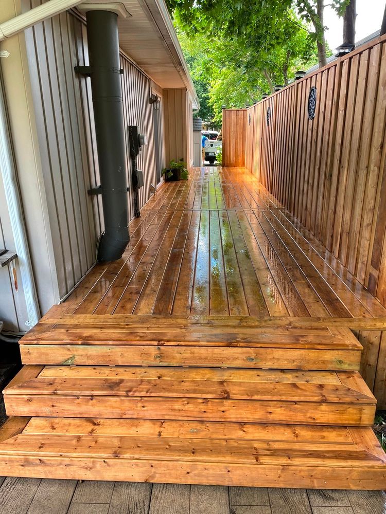 A wooden deck with stairs leading to a house.