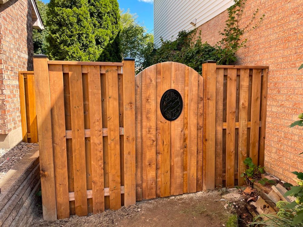 A wooden fence with a gate in the middle of it.