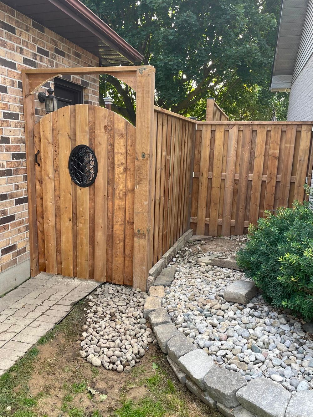 A wooden fence with a gate in the backyard of a house.