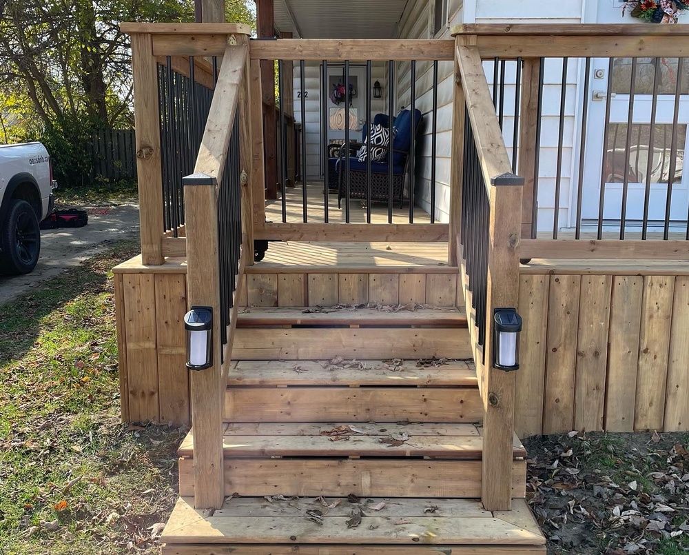 A wooden deck with stairs leading up to a white house.