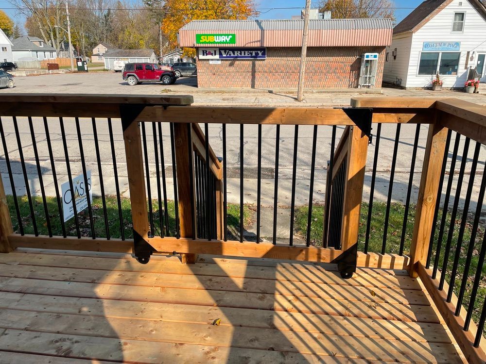 A wooden deck with stairs leading up to a subway restaurant.