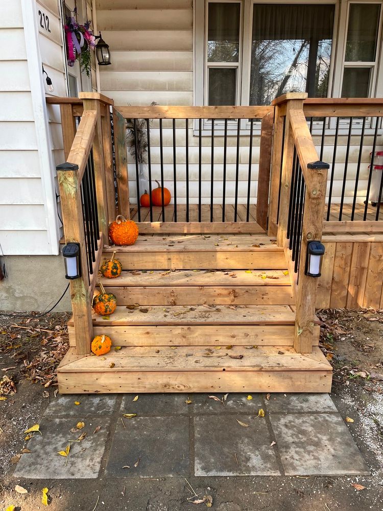 A wooden porch with pumpkins on it in front of a house.