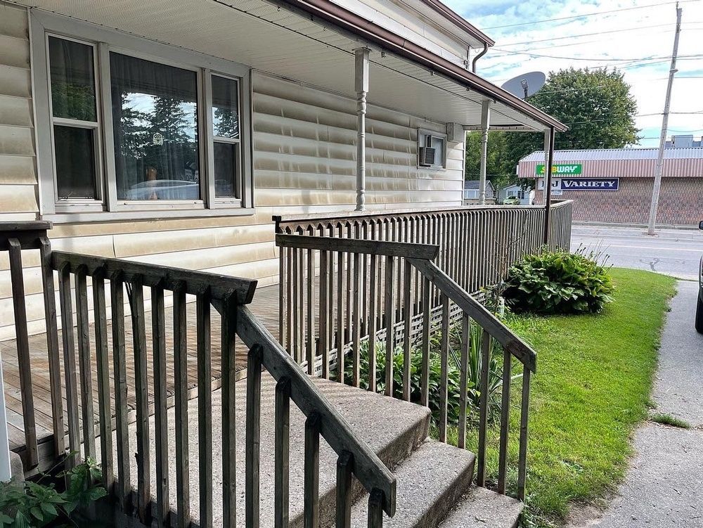 A house with a porch and stairs leading up to it.