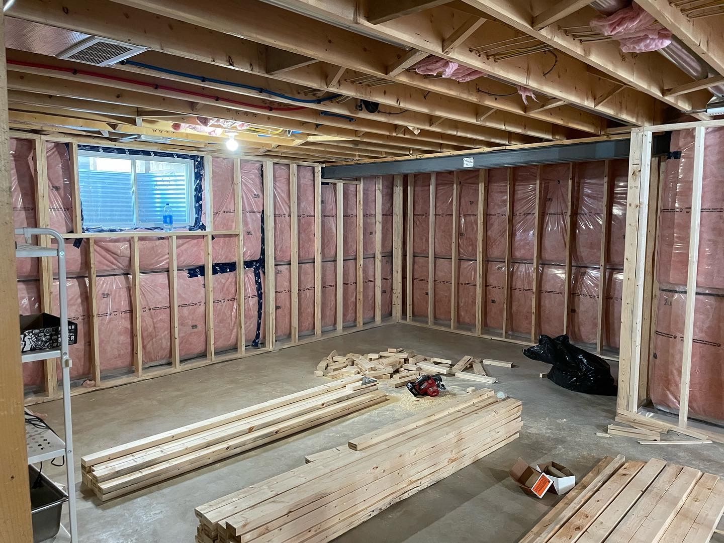 A basement under construction with wooden beams and insulation.
