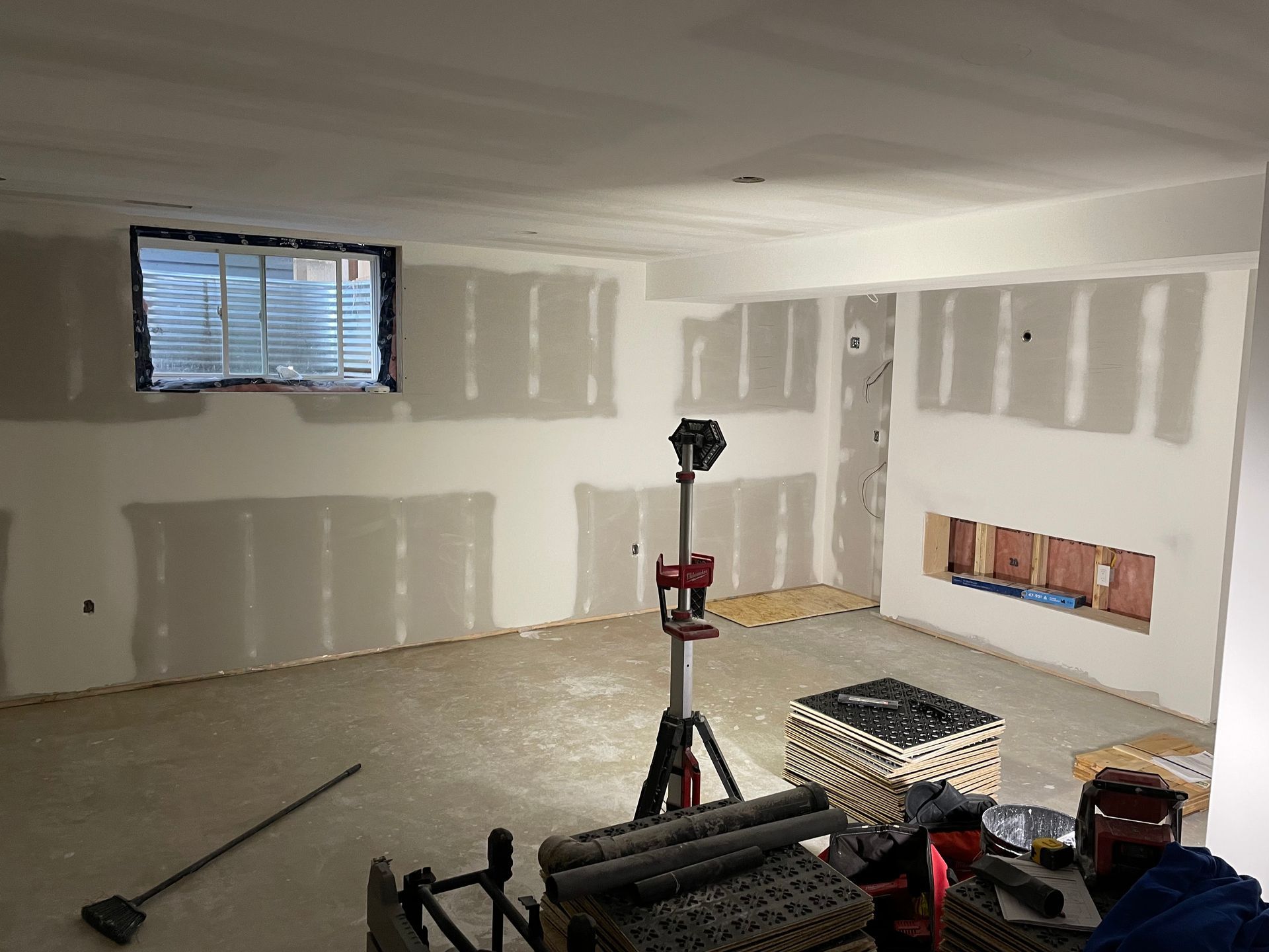 A room with drywall on the walls and a window.